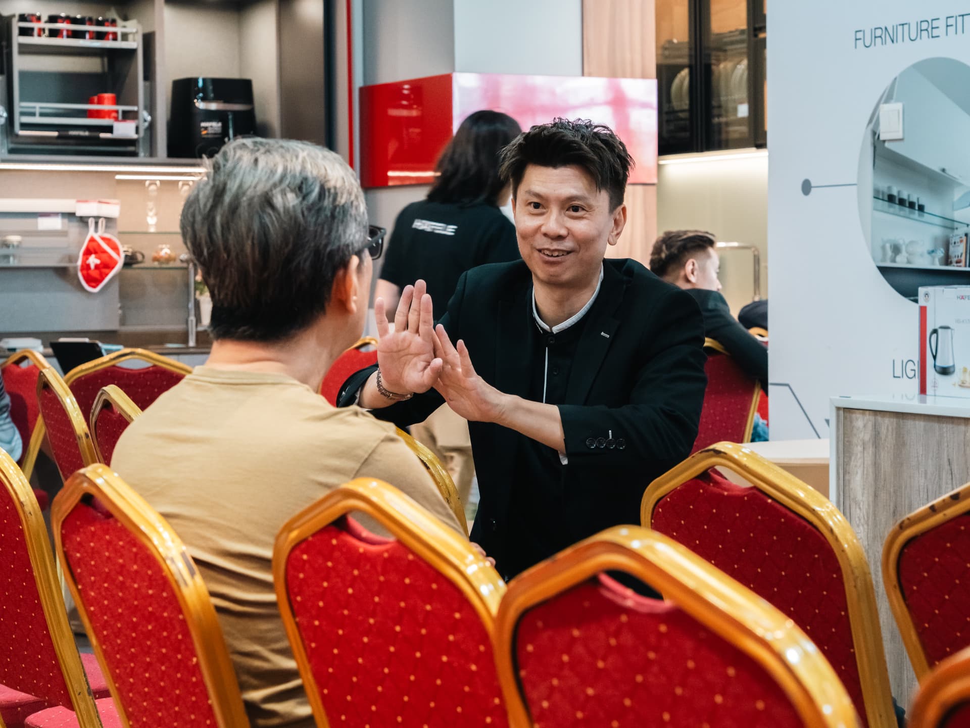 Russell Chin high-fiving a homeowner after a renovation talk