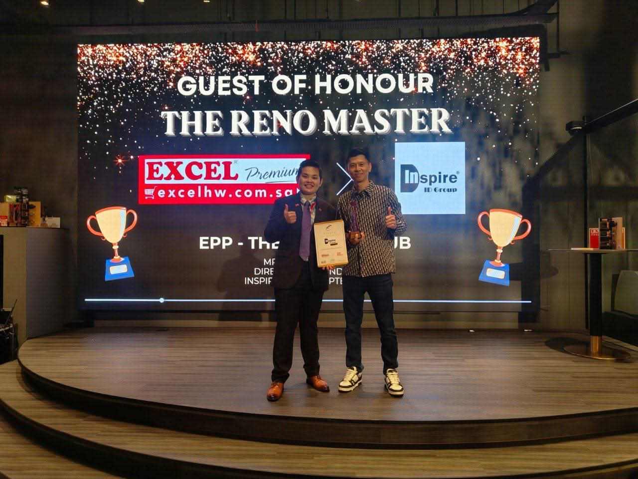 Russell Chin receiving The Singapore Reno Master Award on stage with Excel Hardware